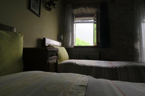 a bedroom with two beds and a window at Rooms Alpe Veglia-Varzo in Varzo