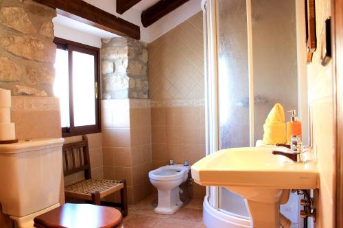 a bathroom with a yellow sink and a toilet at La Muralla in Sabiote