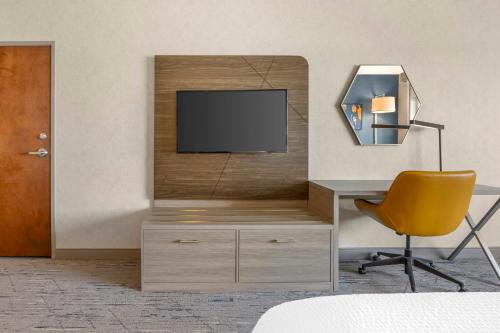 a room with a tv and a desk and a chair at Holiday Inn Express Hotel & Suites Astoria by IHG in Astoria, Oregon
