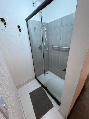 a shower with a glass door in a bathroom at Pousada Cantinho de Minas Da Tânia in Cabo Frio