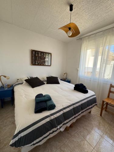une chambre avec un grand lit avec deux oreillers dessus dans l'établissement Front de mer T2 balcon, jardin, garage, proche commerces, à Valras-Plage