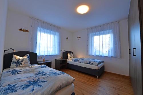 een slaapkamer met twee bedden en twee ramen bij Lärchenheim Appartment in Castelrotto