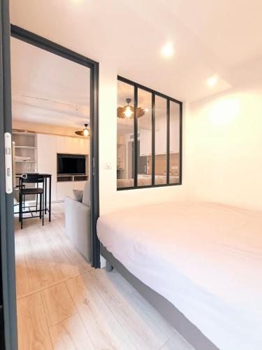 une chambre avec un grand lit blanc et une table dans l'établissement Seytour Central Place, à Nice