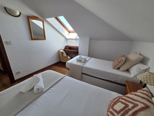 a attic room with two beds and a mirror at Dúplex frente la playa de Ostende in Castro-Urdiales