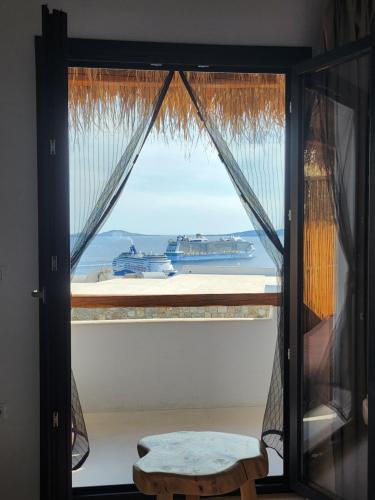 a window with a view of the ocean and boats at ELLI TROPiCAL LUXURY SUITES SUNSET-INFINITY POOL- SEA SIDE-NEAR CENTER PARKING in Mikonos