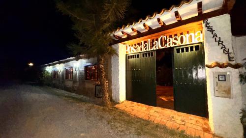 a building with green doors and a sign on it at Posada Campestre La Casona in Villa de Leyva