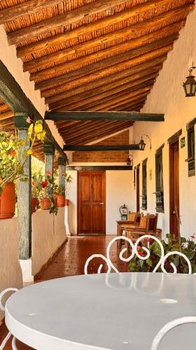 a table and chairs in a room with a wooden ceiling at Posada Campestre La Casona in Villa de Leyva