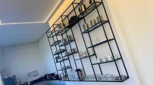a glass shelf on a wall with dishes on it at Hotel Maria Araújo in Arapiraca
