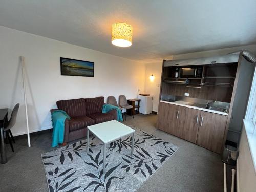 a living room with a couch and a kitchen at Retro cosy unit with lake views and patio walk to town in Queenstown