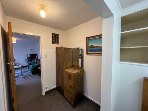 a room with a refrigerator and a room with a desk at Retro cosy unit with lake views and patio walk to town in Queenstown