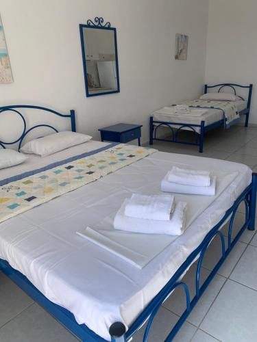 two beds in a room with towels on them at STUDIOs ARSINOI in Agia Paraskevi