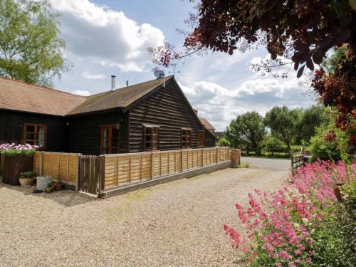 a house with a wooden fence in front of it at Robbie's Barn in Halford