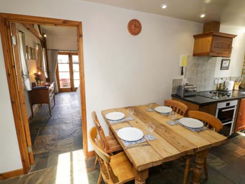 a kitchen with a wooden table with plates on it at Robbie's Barn in Halford