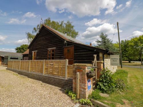 a wooden house with a fence in front of it at Robbie's Barn in Halford