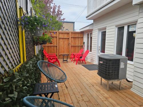 a patio with red chairs and a trash can at Loft de l'Antiquaire by Hébergements DCL in Quebec City