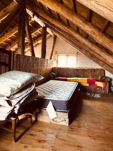a room with two beds and a bench in a attic at Casa grande Los Manzanos in Aiguá