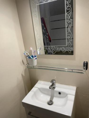 une salle de bain avec un lavabo, un miroir et des brosses à dents dans l'établissement Chti Picard 2 Vue latéral mer et wifi, à Berck-sur-Mer