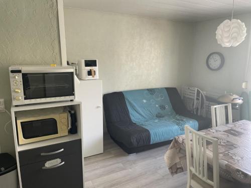 Cette petite chambre comprend un lit et un four micro-ondes. dans l'établissement Chti Picard 2 Vue latéral mer et wifi, à Berck-sur-Mer