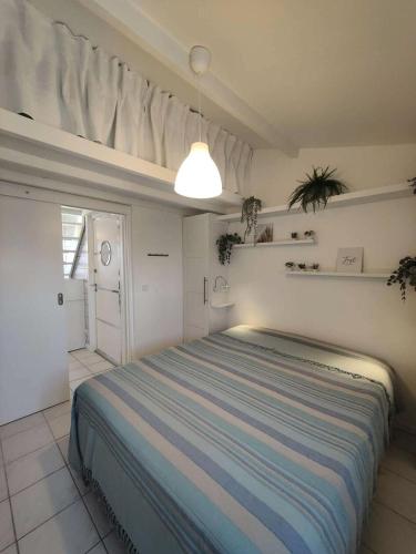 une chambre avec un lit dans une pièce blanche dans l'établissement Résidence Bar061-le Barcares - Appartement climatisé vue sur l'eau - T2 mezzanine - 4 couchages - animaux non acceptés MAE-8993, au Barcarès
