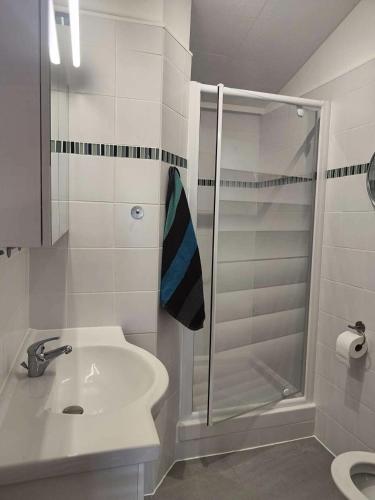 une salle de bain blanche avec une douche et un lavabo dans l'établissement Résidence Bar061-le Barcares - Appartement climatisé vue sur l'eau - T2 mezzanine - 4 couchages - animaux non acceptés MAE-8993, au Barcarès