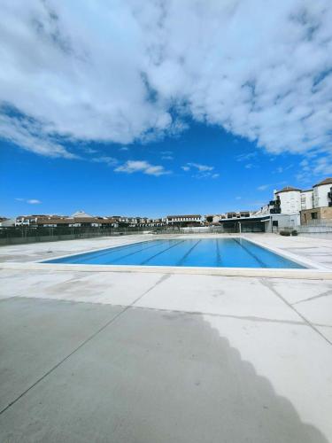 une piscine vide avec un ciel nuageux dans l'établissement Résidence Bar061-le Barcares - Appartement climatisé vue sur l'eau - T2 mezzanine - 4 couchages - animaux non acceptés MAE-8993, au Barcarès