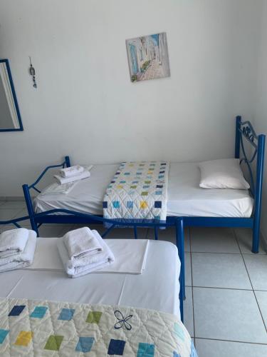 a room with two beds with towels on them at STUDIOs ARSINOI in Agia Paraskevi