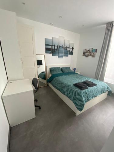 a white bedroom with a bed and a desk at Studio à cote du parc des expositions porte de Versailles, proche metro in Vanves