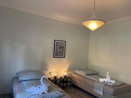 ヴェッセリングにあるCozy Private 3-Bedroom Apartment in Wesselingのベッドが2つとランプとキャンドルのある部屋