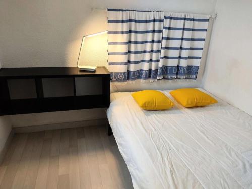 - une petite chambre avec un lit et 2 oreillers jaunes dans l'établissement Résidence Terrasses De La Mediterranee 3 - APPT T2 4 couchages PORT LEUCATE MAE-7604, à Port-Leucate