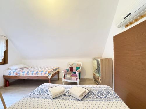 a bedroom with two beds and a chair at The Garden Tiny Homes in Ayvacık