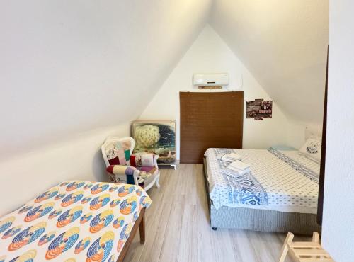 a attic bedroom with a bed and a chair at The Garden Tiny Homes in Ayvacık
