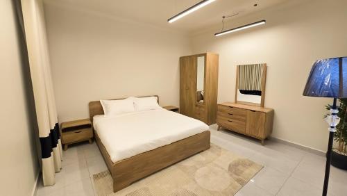 a bedroom with a bed and a dresser and a mirror at شقق سكنية مفروشة فاخرة - مكة الشرائع in Ash Sharāʼi‘