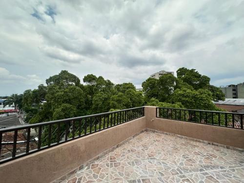 a balcony with a railing and trees in the background at Suite con terraza privada in Cali
