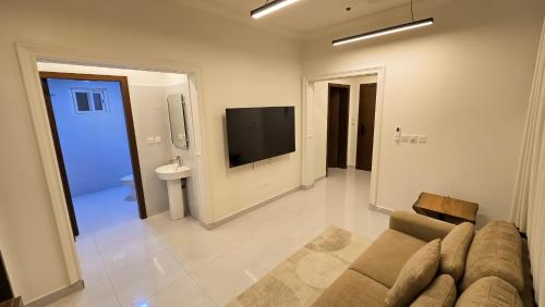 a living room with a couch and a flat screen tv at شقق سكنية مفروشة فاخرة - مكة الشرائع in Ash Sharāʼi‘
