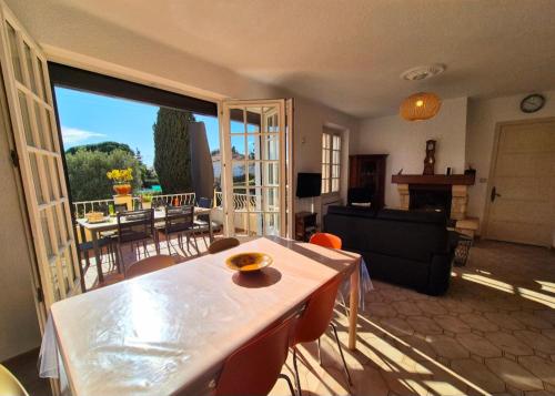 un salon avec une table et un salon avec vue dans l'établissement Maison familliale, vaste jardin proche mer et centre ville, à Bandol
