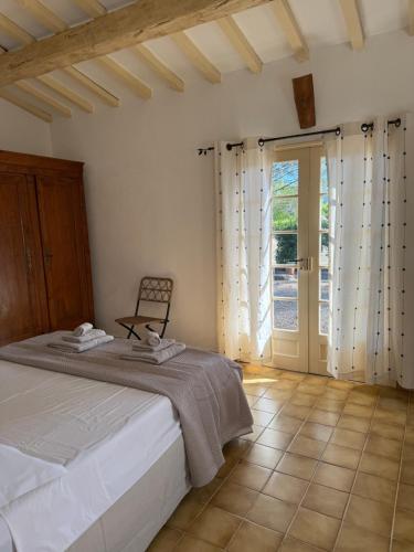 une chambre avec un lit et une porte coulissante en verre dans l'établissement Le mazet du grand pin, à Cogolin