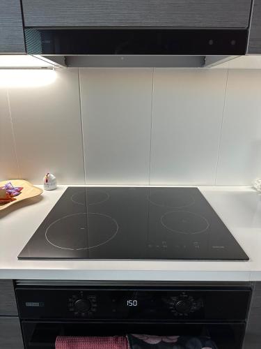 a stove top oven in a kitchen with white cabinets at The Cutest Studio in Central Tampere in Tampere