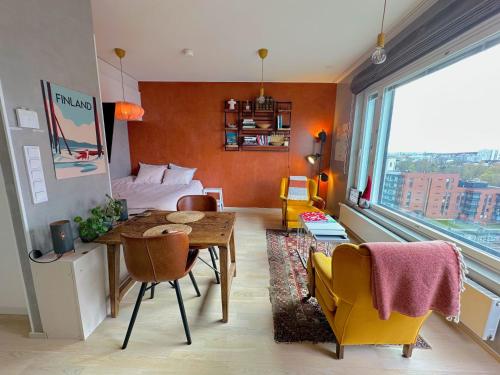 a room with a bed and a table and chairs at The Cutest Studio in Central Tampere in Tampere