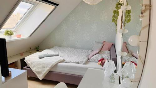 a small attic bedroom with a bed and a window at Idyllisches Dorfhaus vor Usedom in Gützkow
