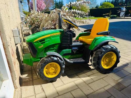 a green toy tractor parked next to a building at Idyllisches Dorfhaus vor Usedom in Gützkow