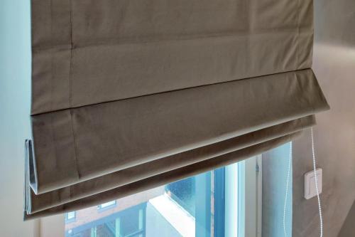a window with a brown blinds on a window at The Cutest Studio in Central Tampere in Tampere