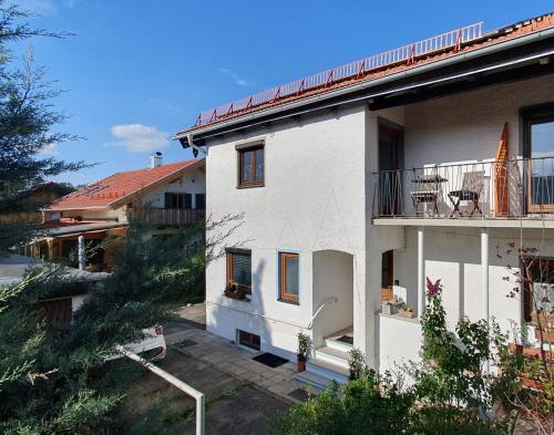 a white house with a balcony on the side of it at Ferienwohnung Alztal - mit Wallbox in Altenmarkt an der Alz