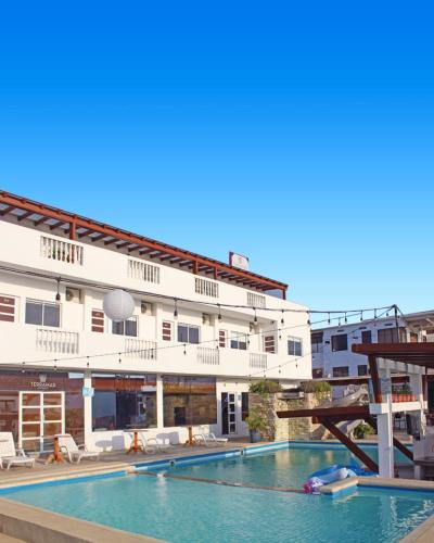 a hotel with a swimming pool in front of a building at Terramar Hoteles in Crucita