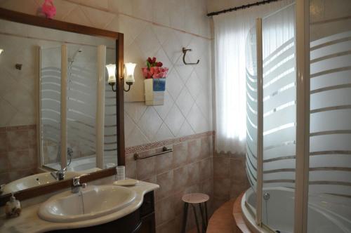 un bagno con un lavandino, una vasca e uno specchio di Casa Rural Los Galanes a Villanueva de los Infantes