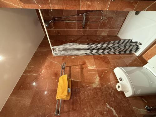 La salle de bains est pourvue de toilettes et d'une serviette jaune. dans l'établissement Canigou 15 by Confortsky, au Pas de la Case