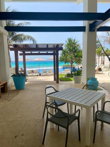 a patio with a table and chairs and the beach at Cozy and Modern in Cancún