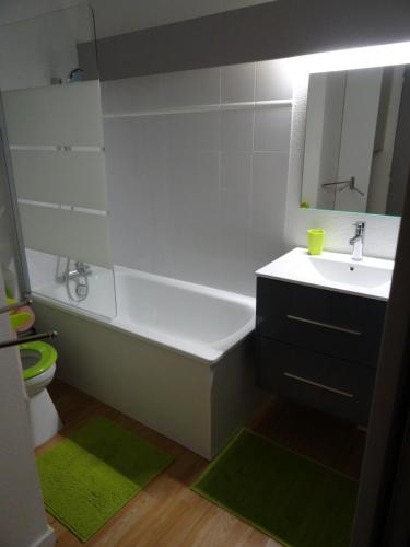 une salle de bain avec une baignoire, un lavabo et un miroir dans l'établissement Joli studio rénové 5p avec parking à La Mongie Tourmalet, à Bagnères-de-Bigorre