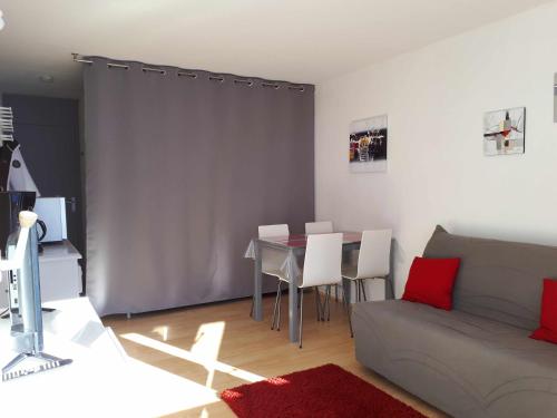 un salon avec un canapé et une table avec des chaises dans l'établissement Joli studio rénové 5p avec parking à La Mongie Tourmalet, à Bagnères-de-Bigorre