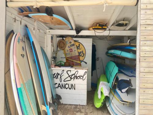 a room filled with surfboards and other surfboards at Cozy and Modern in Cancún