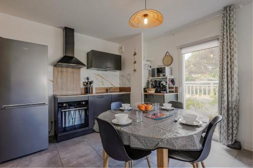 Il comprend une cuisine et une salle à manger avec une table et des chaises. dans l'établissement Appartement T2 idéal 2 personnes-150 m de la plage, à Biscarrosse